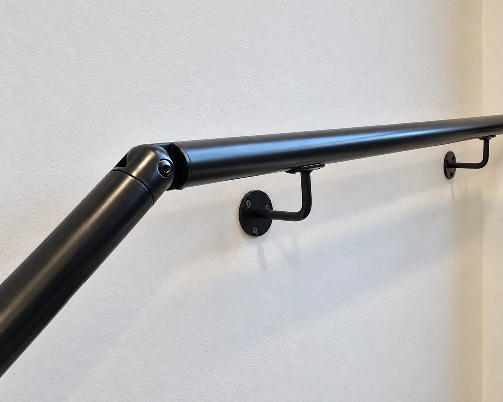 Black modular handrail with wall brackets and angled connector Black modular handrail with wall brackets and angled connector