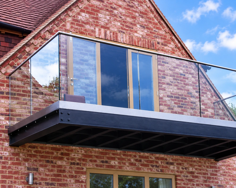 Frameless glass balustrade around a balcony on a brick house