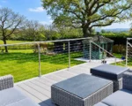 Stainless steel balustrade with horizontal wire infill around garden decking